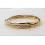 A 9ct gold double design bangle, inner dimensions approx 5.8cm x 5.2cm, weight 8.2gms Condition
