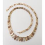 A three colour gold fringe necklet, width at widest point 1cm, length 37cm, weight 21gms Condition