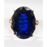 A 9ct gold ring set with a large blue glass gem, finger size N, weight 5.6gms Condition Report: