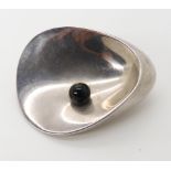 A silver Georg Jensen 'Oyster' brooch set with an onyx ball, designed by Nanna and Jorgen Ditzel.