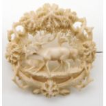 A carved antler brooch depicting deer in a woodland Condition Report: Not available for this lot