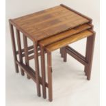 A mid-Century rosewood nest of three tables, 50cm high x 49cm wide x 37cm deep A CITIES