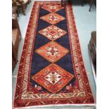 A blue ground Karajeh runner with five central lozenges, 310cm x 118cm Condition Report: Available