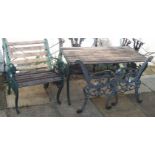 A cast iron garden table with wooden slats and matching chair and a pair of cast iron bench ends