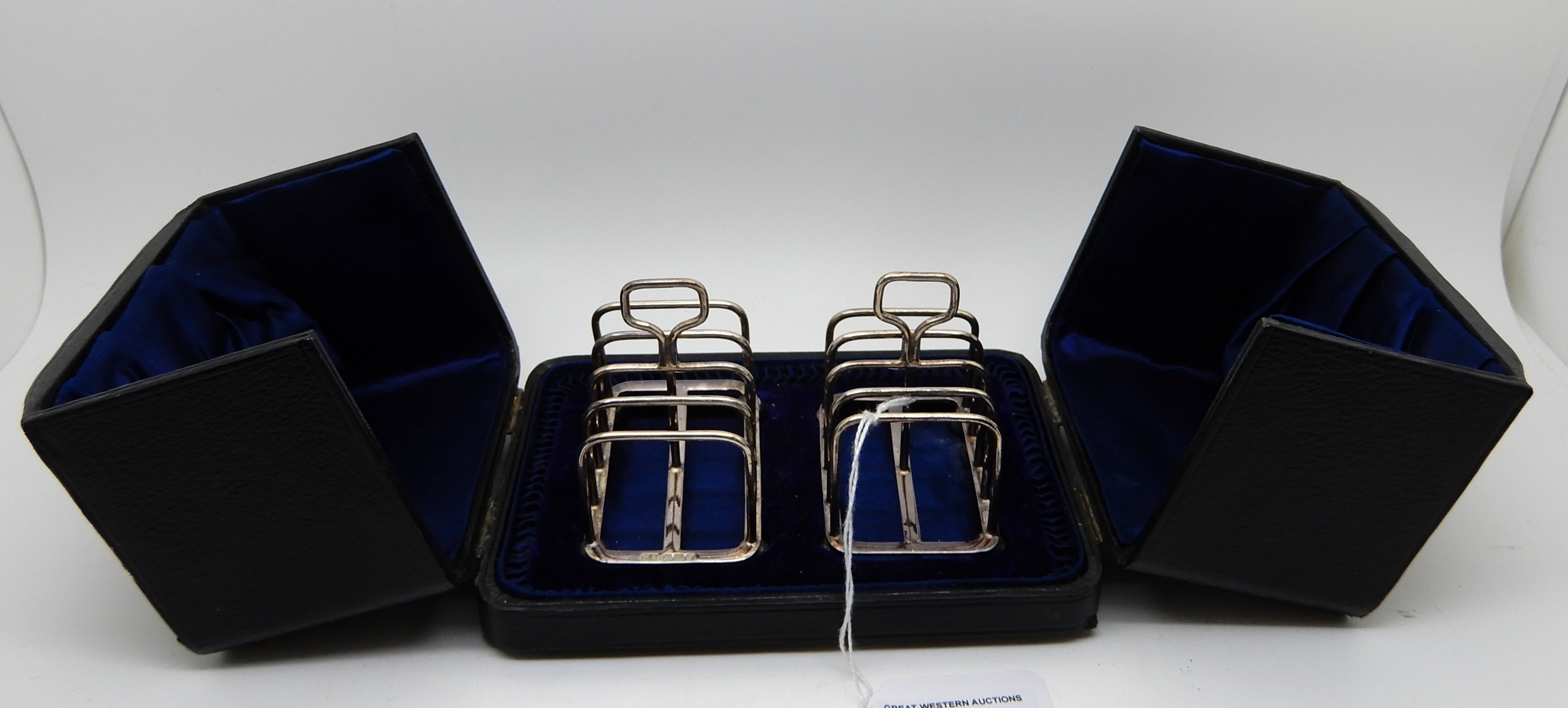 A cased pair of silver toast racks, Sheffield 1908, four section on ball feet, 6.8cm long, 96gms