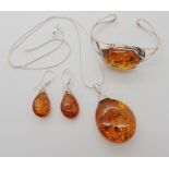 A collection of silver and amber jewellery to include a bangle, pendant and earrings Condition