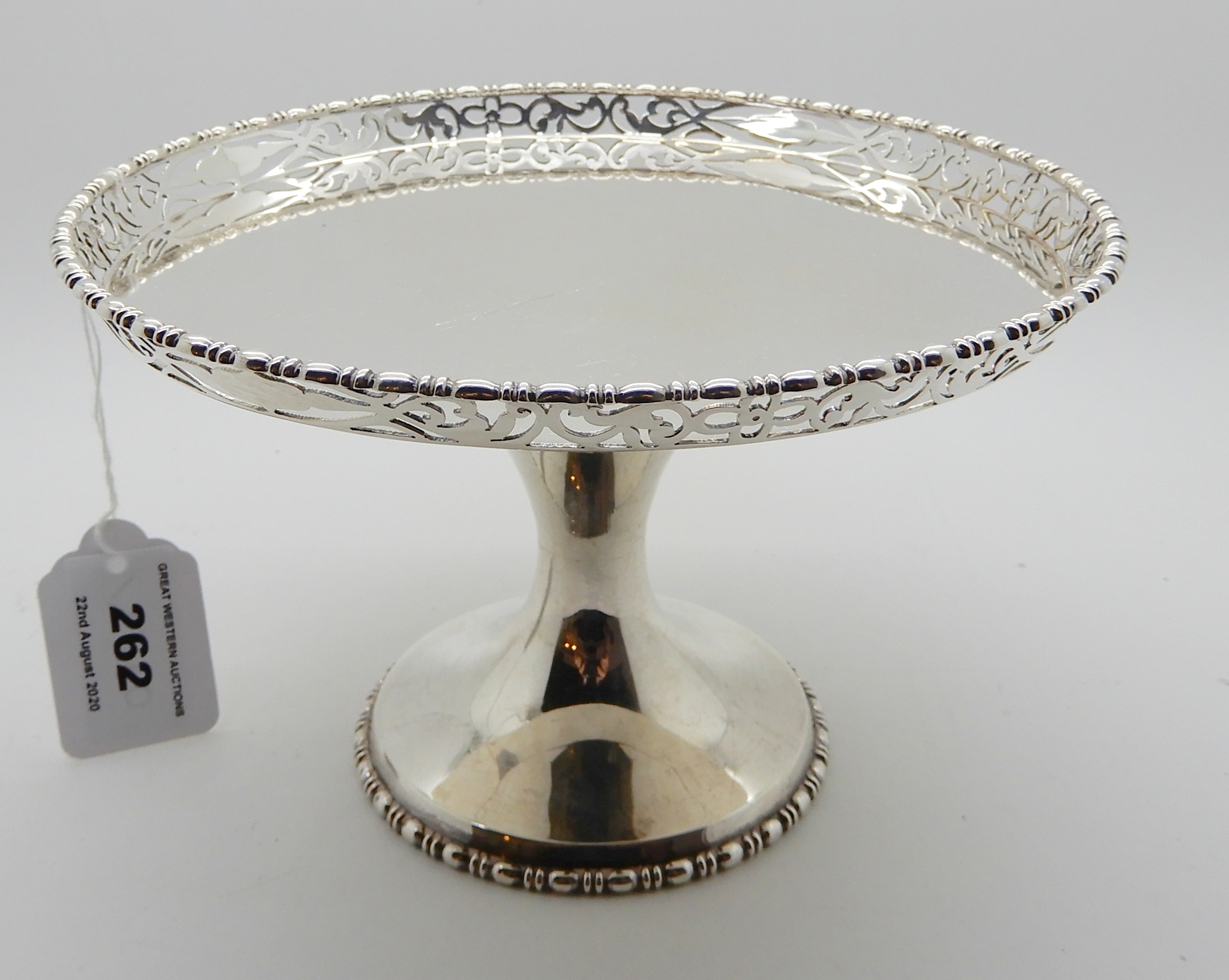 A silver tazza with a circular flat with pierced decorated rim, 12cm high, 411gms Condition