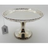 A silver tazza with a circular flat with pierced decorated rim, 12cm high, 411gms Condition