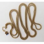 A long 9ct gold box chain, length 152cm, with an attached baby boots charm to the safety chain,