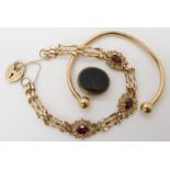 A 9ct gold garnet set gate bracelet length 19.2cm, a 9ct gold bangle and a partial fob seal,