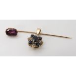 A yellow metal purple sapphire set stick pin, silk inclusions are visible, dimensions 10.5mm x 7.