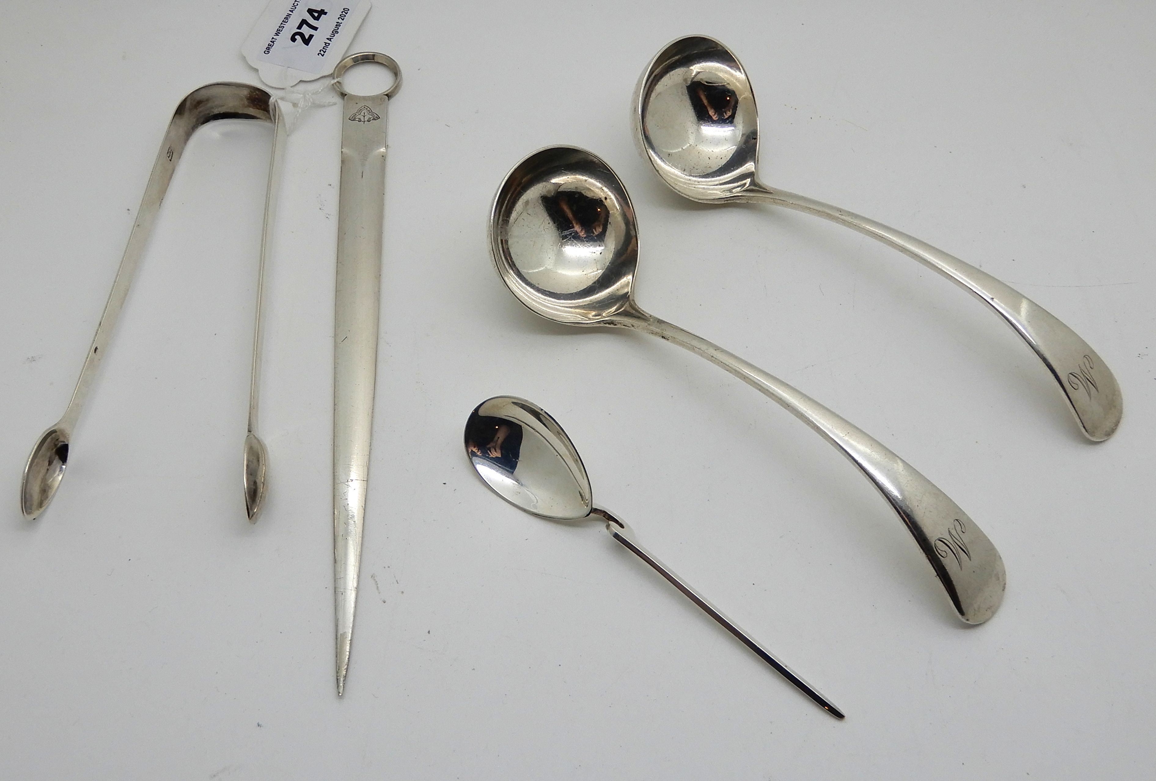 A lot comprising a pair of Georgian silver sugar tongs, London 1814, a pair of silver toddy ladles,