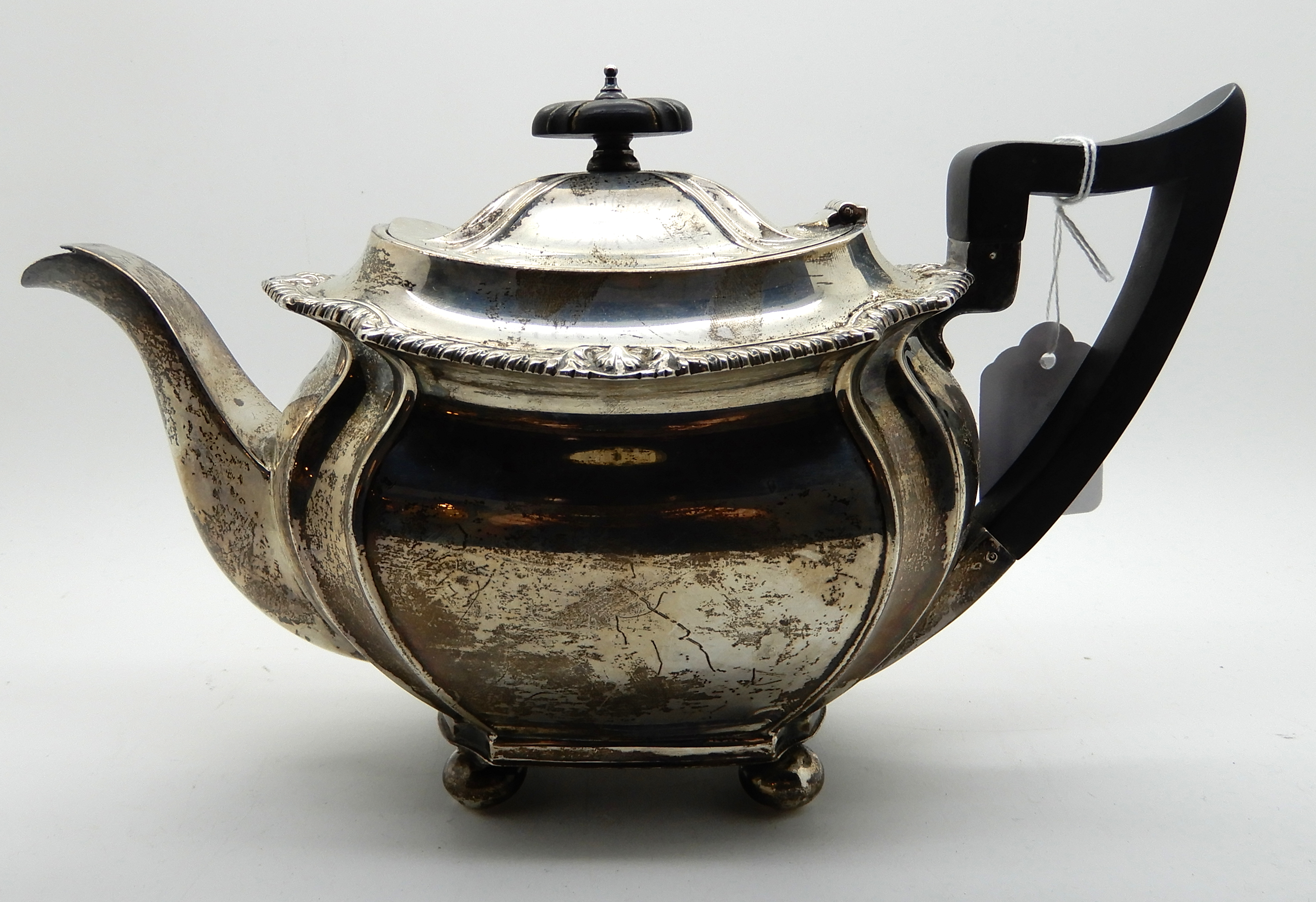 A silver teapot, Sheffield 1919, of rounded rectangular form and four ball feet, 16cm high, 704gms - Image 2 of 4