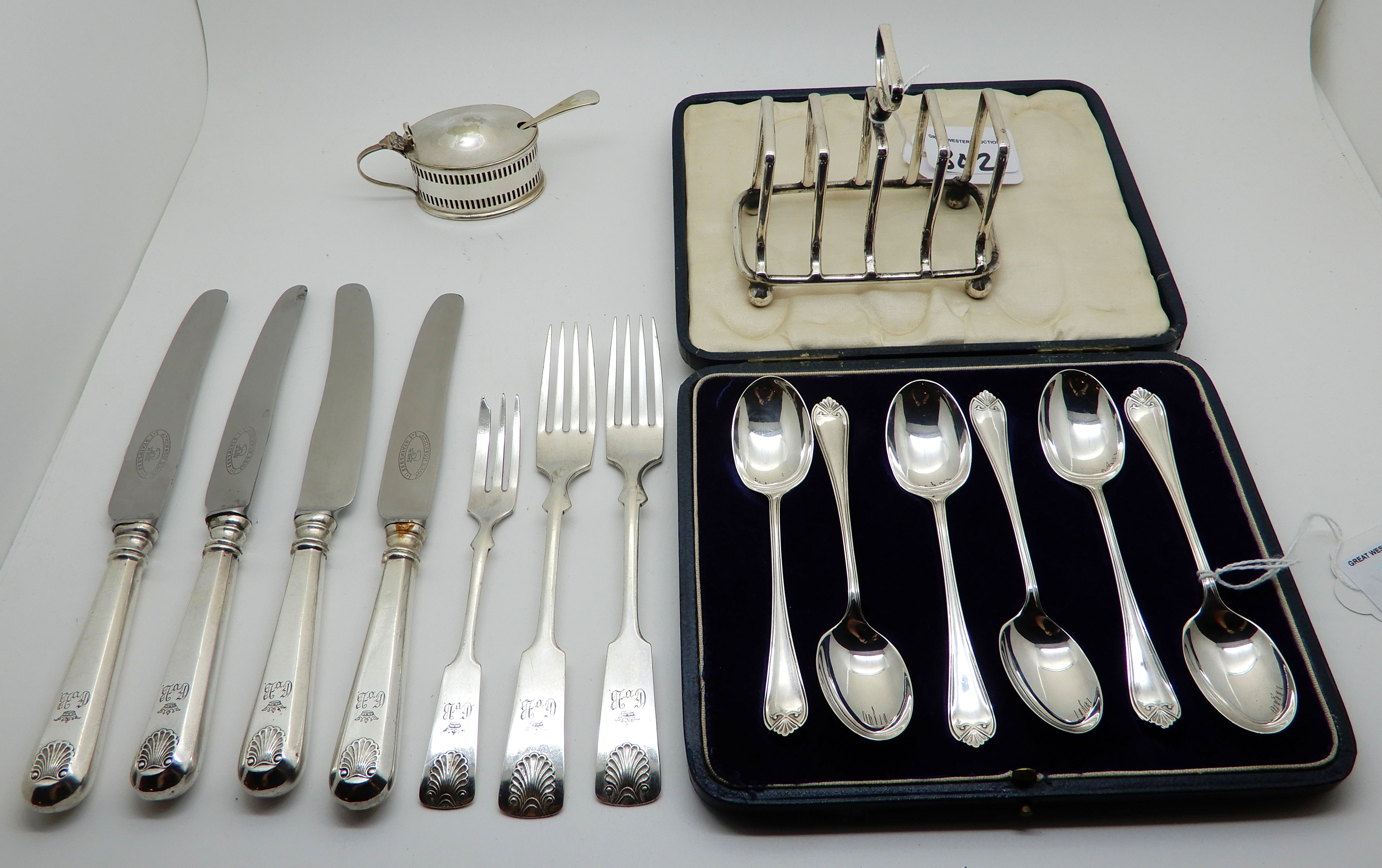 A lot comprising a cased set of six silver teaspoons, Sheffield 1930, with EP toast rack, mustard