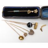 A collection of stick pins to include two yellow metal pearl set pins, the yellow metal mount from a