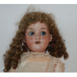An Armand Marseille bisque-headed doll, fixed blue eyes, open mouth and painted features with