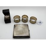 A lot comprising a silver cigarette case, three silver napkin rings, (171gms), various marks and a