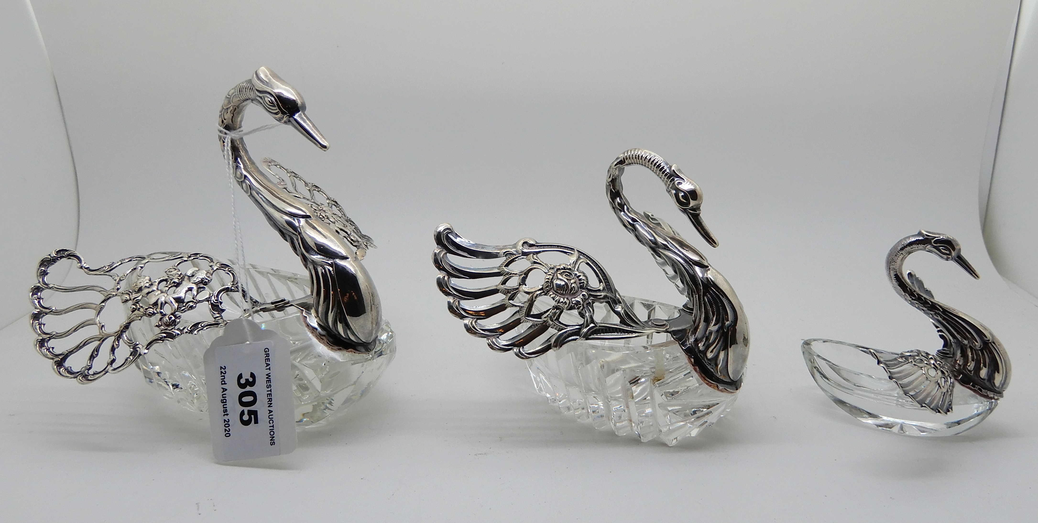 A graduated set of three continental white metal and glass trinket dishes modelled as swans
