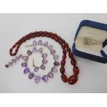 A gilded white metal graduated amethyst necklace with matching brooch, a string of cherry amber