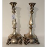 A pair of continental white metal candlesticks with knopped stems, the rounded square bases with