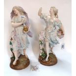 A pair of continental figures of maidens one modelled holding flowers, the other a flaming lamp,