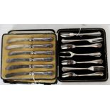 A lot comprising a cased set of six silver cake forks, Birmingham 1915 and a cased set of silver