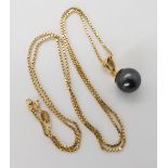 An 18ct gold box chain length 54cm and yellow metal black pearl pendant, weight 8gms Condition