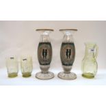 A vaseline glass jug and two tumblers with etched decoration of grasses and a pair of vases with