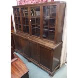 An oak bookcase with four glazed doors over a base with four doors, 185cm high x 183cm wide x 47cm