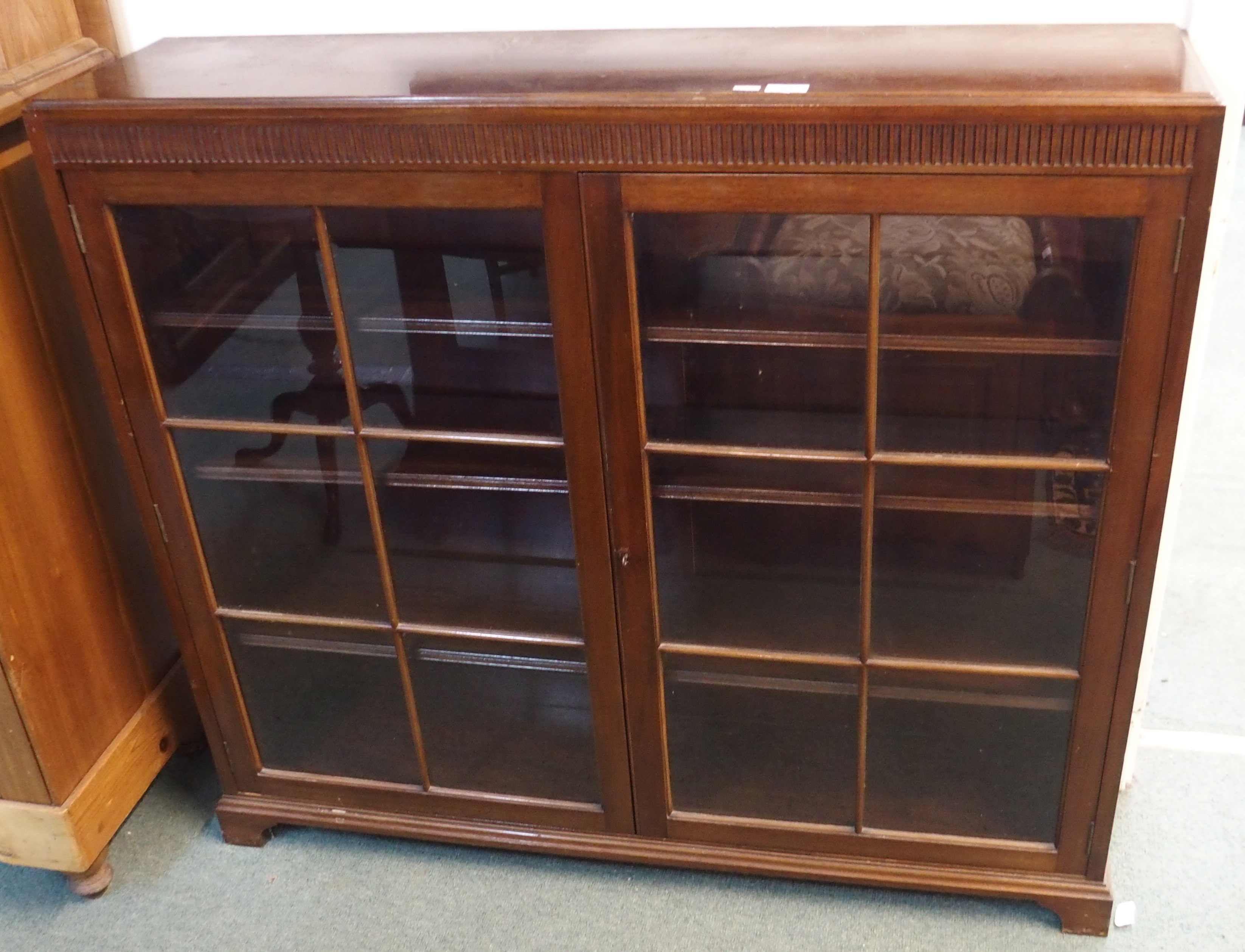 A mahogany two door glazed bookcase, 103cm high x 120cm wide x 29cm deep Condition Report: Available