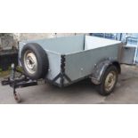 A car trailer with wooden sides and spare wheel