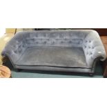 A Victorian grey upholstered Chesterfield three seater sofa with carved feet, 70cm high x 220cm wide