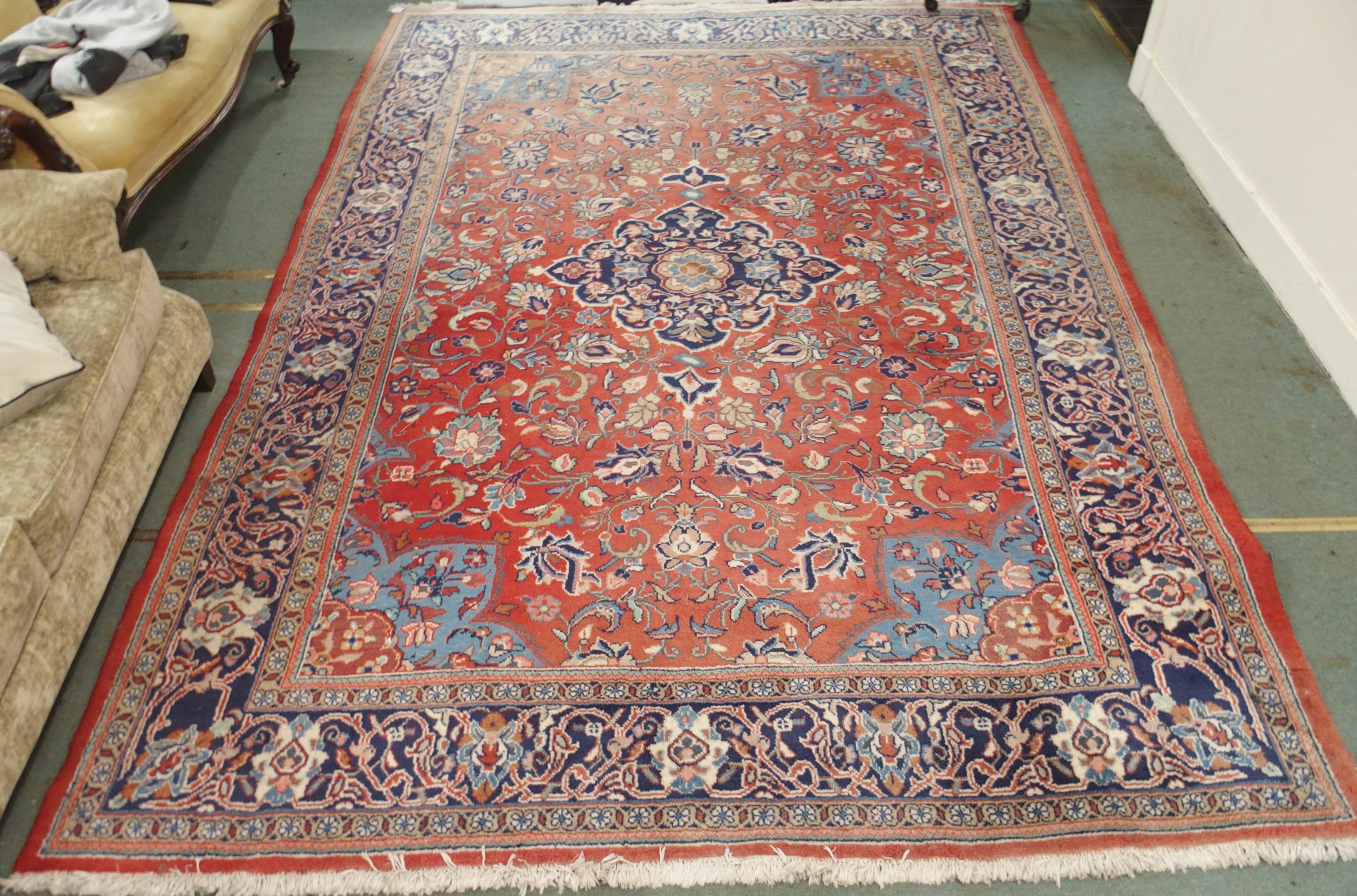 A red ground Keshan rug with blue central medallion, 342cm x 230cm Condition Report: Available