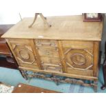 An oak sideboard with four central drawers flanked by two doors on carved stand, 93cm high x 128cm