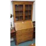 An oak bureau bookcase with two glazed doors, three drawers on bracket feet, 191cm high x 89cm