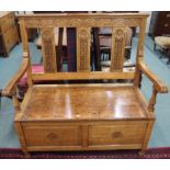 A carved oak bench with lidded seat, 110cm high x 110cm wide x 55cm deep Condition Report: Available