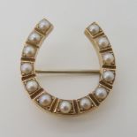 A yellow metal pearl set horseshoe brooch, 2.3cm x 2.2cm, weight 2.7gms Condition Report: