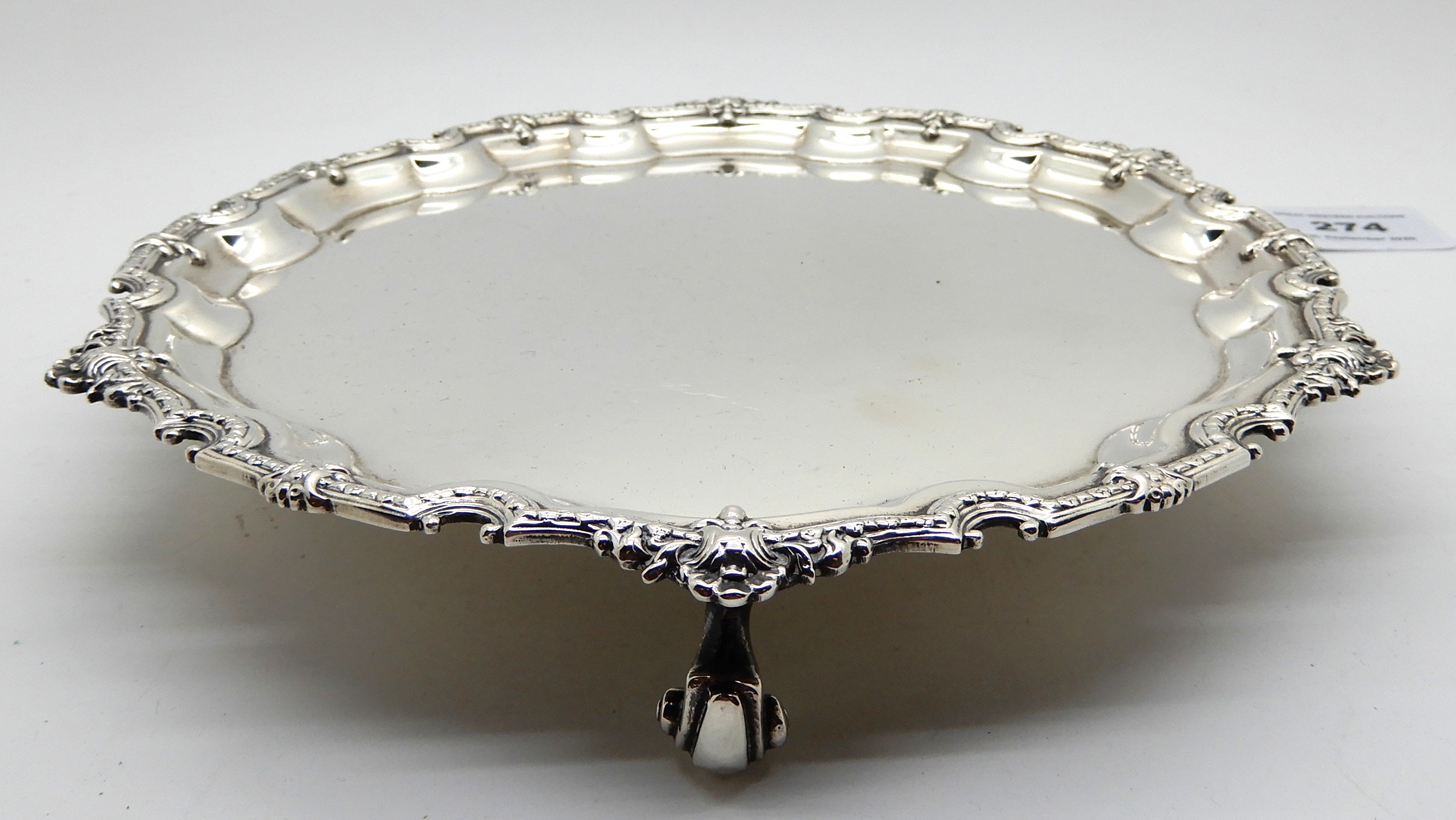 A silver card tray, Birmingham 1973, of circular form, the scalloped rim with shell motif on three