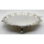 A silver card tray, Birmingham 1973, of circular form, the scalloped rim with shell motif on three