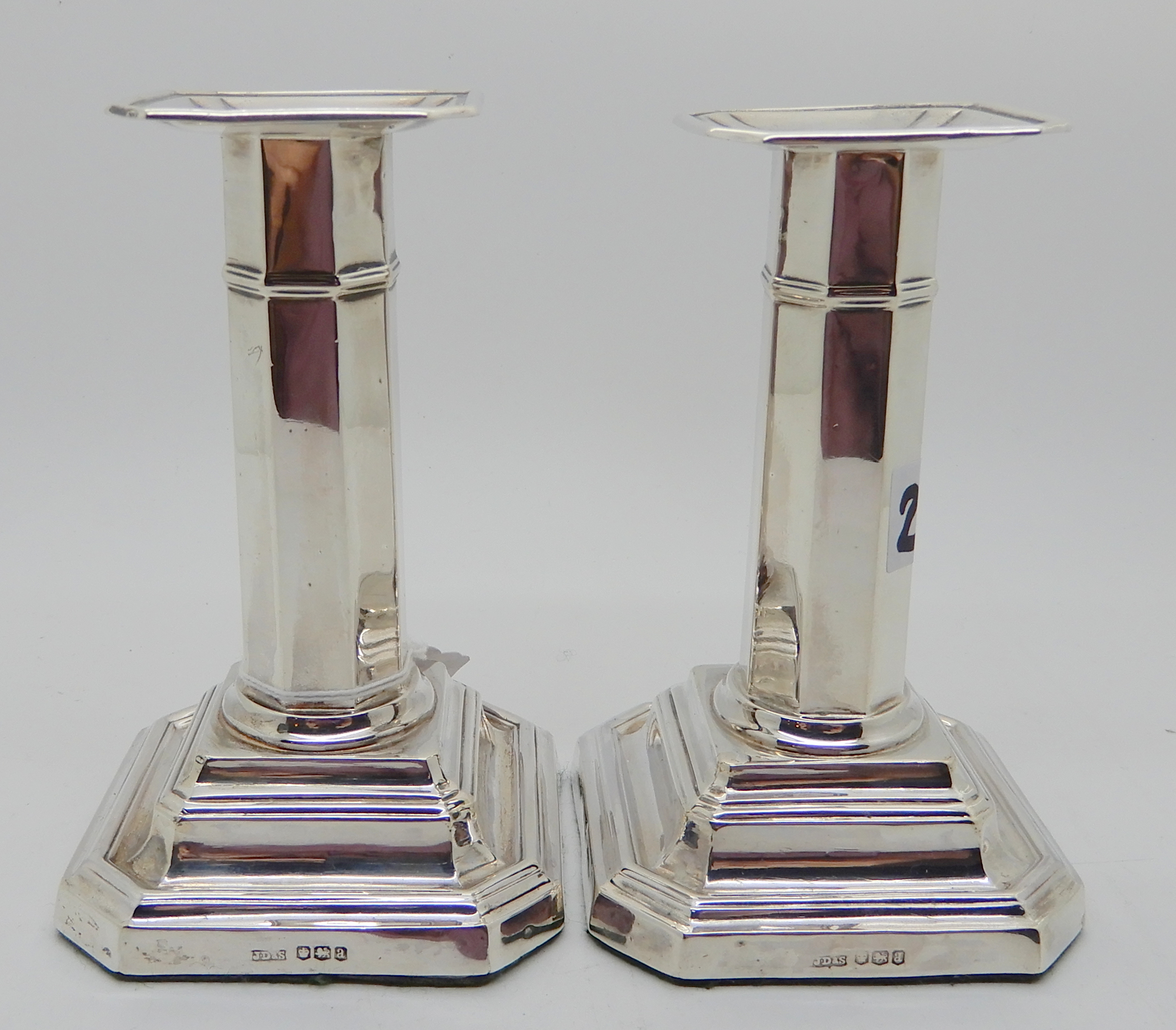 A pair of silver candlesticks, Sheffield 1918, the octagonal stem on stepped square pedestal base