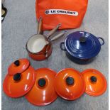 A Le Cruset blue enamel casserole pot and lid and three orange saucepans and lids Condition