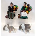 Two Royal Doulton figures, The Old Balloon Seller and The Balloon Man and two Lladro puppies