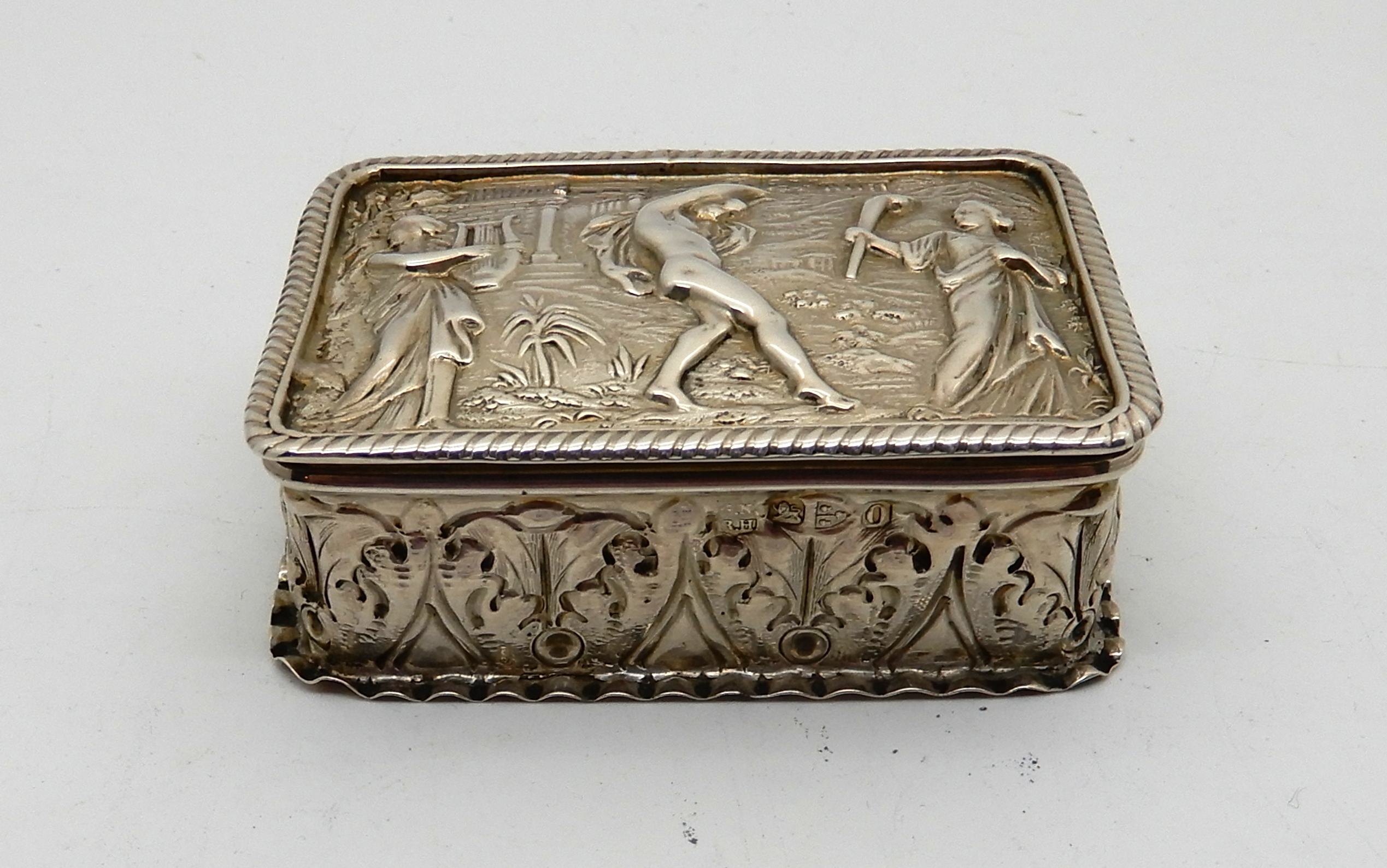 A white metal snuff box, rectangular embossed with classical figures, 6.8cm x 4.8cm