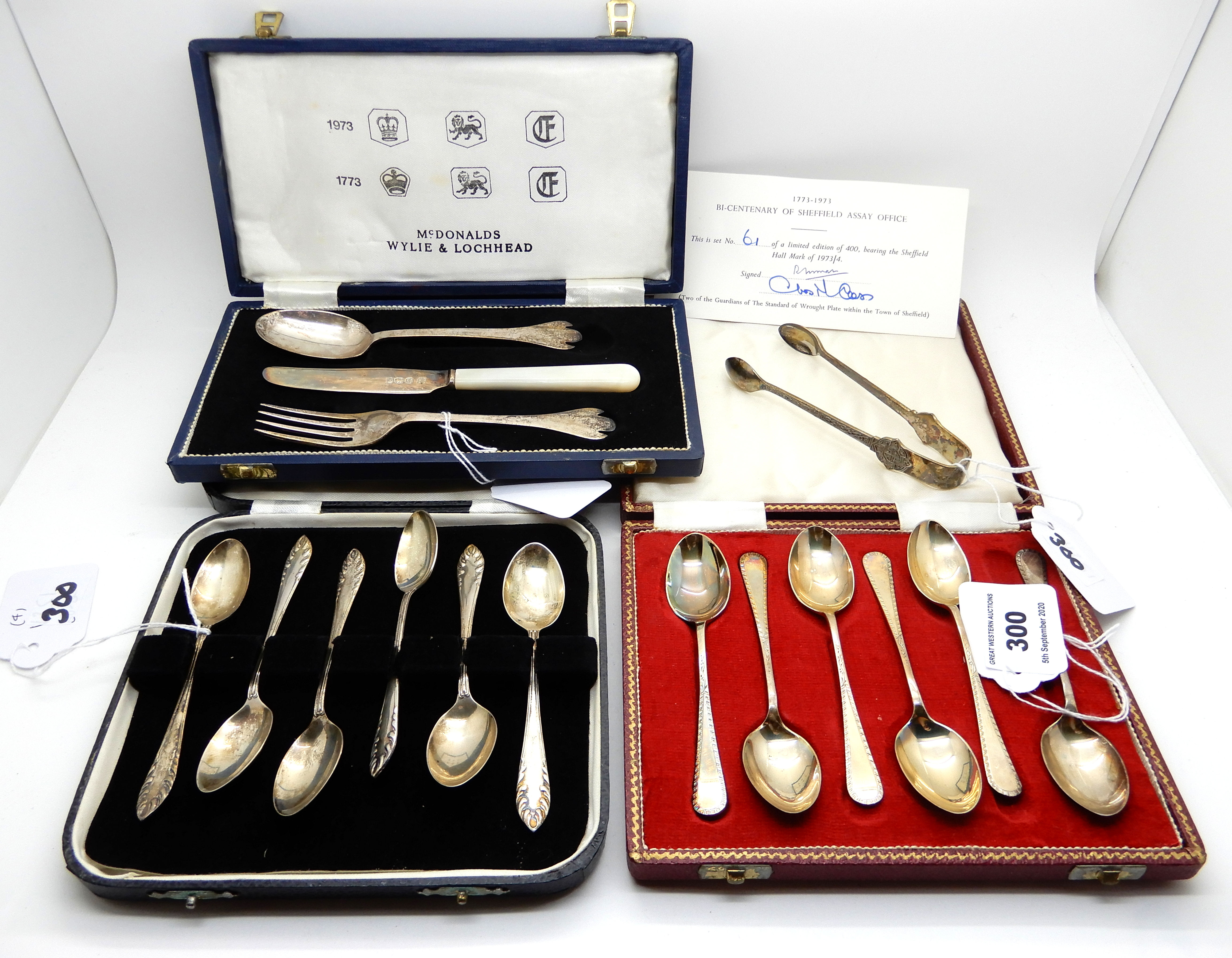 A lot comprising two cased sets of six silver coffee spoons, a cased three piece silver