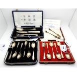 A lot comprising two cased sets of six silver coffee spoons, a cased three piece silver