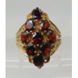 A 9ct gold garnet cluster ring, head size 2.5cm x 1.4cm, finger size Q1/2, weight 7.6gms Condition