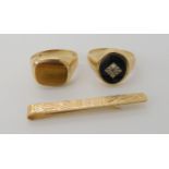 A 9ctgold monogrammed tie clip, together with an onyx signet ring size O1/2, and a 9ct tigers eye