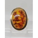 A 9ct gold mounted amber ring head size 20mm x 15mm, size N, weight 4.6gms Condition Report:
