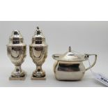A lot comprising a pair of silver pepperettes, London 1955 (weighted) and a silver mustard pot,