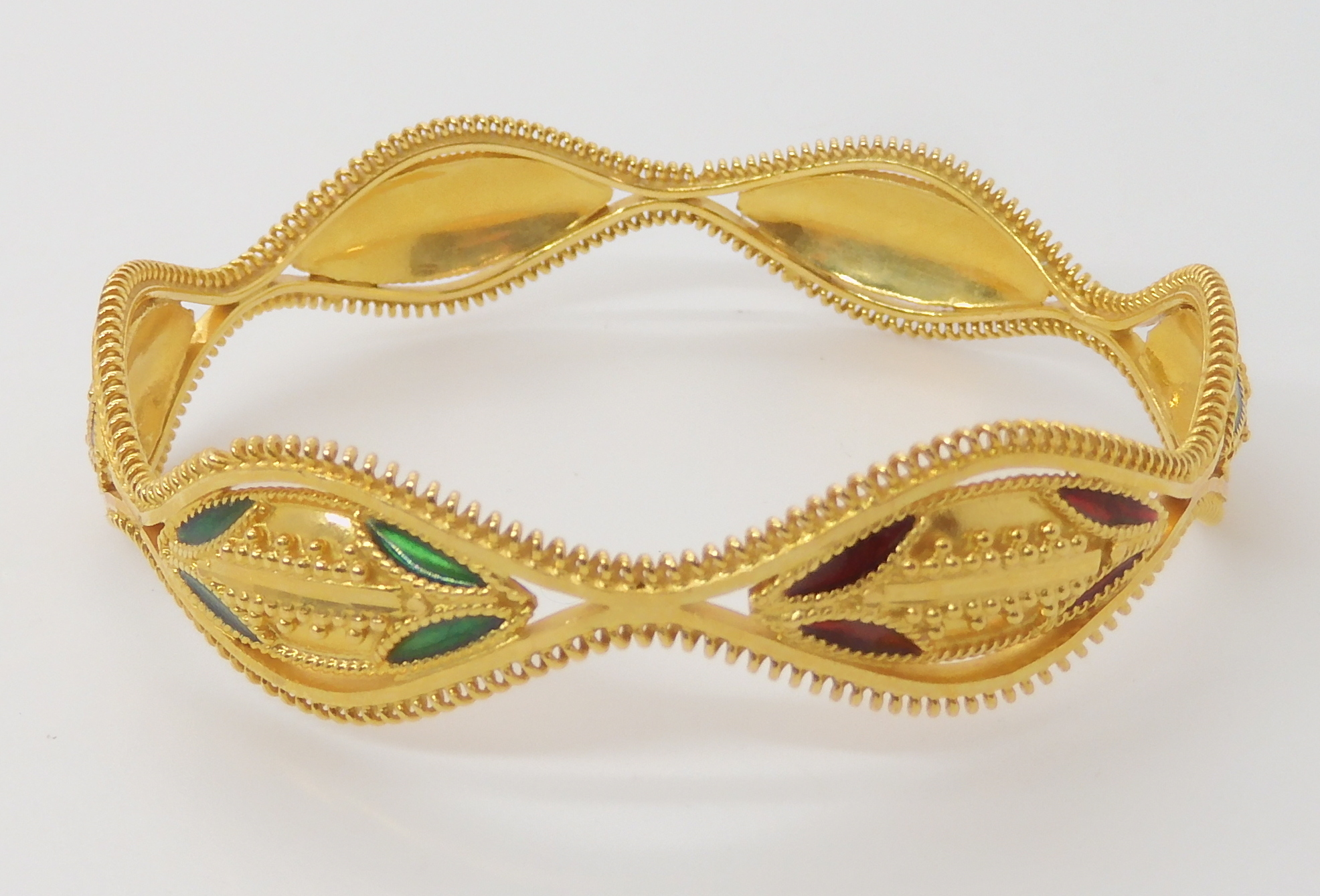A BRIGHT YELLOW METAL DECORATIVE BANGLE with red and green enamel and granulation detail, stamped - Image 2 of 4